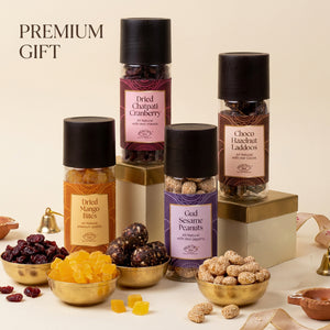 Utsav Rakhi Gift Hamper | Chatpati Cranberry, Dried Mango, Gud Sesame Peanut, Chocolate Hazelnut Laddoo, Scented Candle, Handmade Rakhi Pair, Roli Chawal & Greeting Card